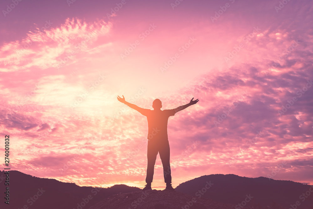 Backpacker man raise hand up on top of mountain with sunset sky and clouds abstract background.