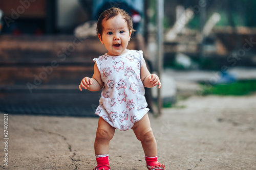 Valokuva little one year old girl with dark hair play on yard at home