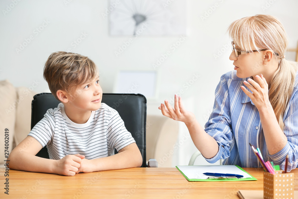 Female psychologist working with little boy in office Female psychologist working with little boy in office