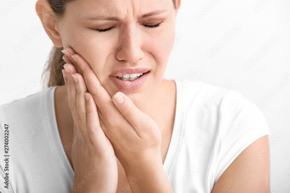 Young woman suffering from toothache on white background Young woman suffering from toothache on white background