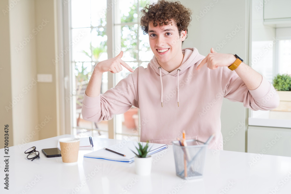 Young student man writing on notebook and studying looking confident with smile on face, pointing oneself with fingers proud and happy. Young student man writing on notebook and studying looking confident with smile on face, pointing oneself with fingers proud and happy.