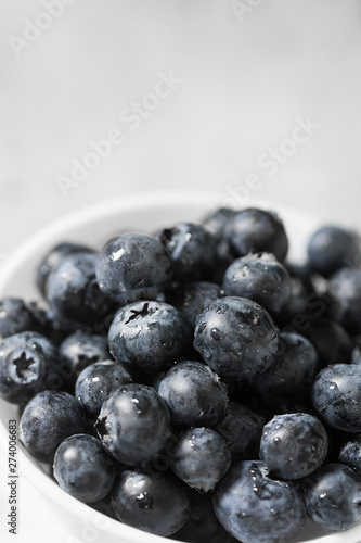 Blueberries in a white bowl on a light background