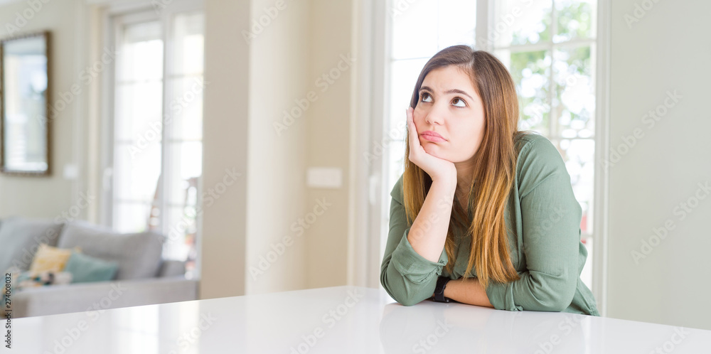 Beautiful young woman at home thinking looking tired and bored with depression problems with crossed arms. Beautiful young woman at home thinking looking tired and bored with depression problems with crossed arms.