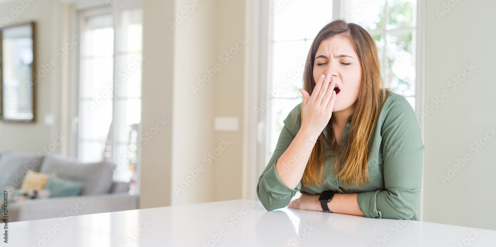 Beautiful young woman at home bored yawning tired covering mouth with hand. Restless and sleepiness. Beautiful young woman at home bored yawning tired covering mouth with hand. Restless and sleepiness.