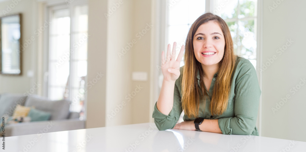 Beautiful young woman at home showing and pointing up with fingers number four while smiling confident and happy. Beautiful young woman at home showing and pointing up with fingers number four while smiling confident and happy.