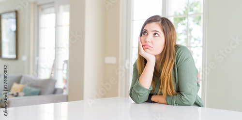 Beautiful young woman at home thinking looking tired and bored with depression problems with crossed arms.