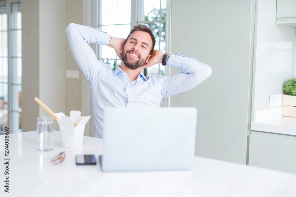 Business man eating take away asian noodles food while working using computer laptop and smiling