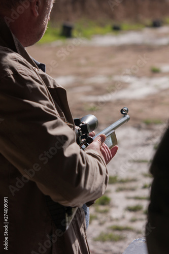 Man holding a modern rifle preparing to shoot a target