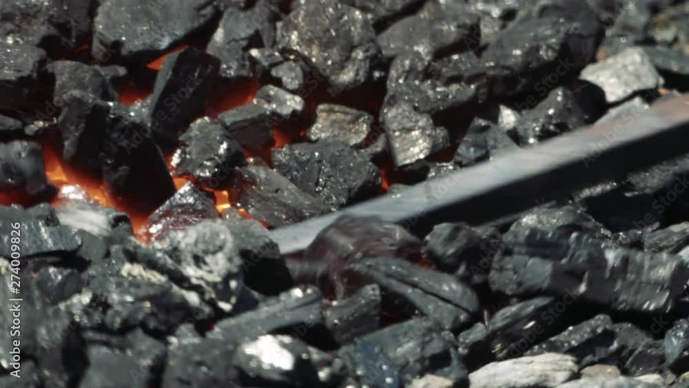 Close Up of Hot Metal Bar Being Heated in a Coal Forge in the Blacksmith Shop with Flame Close Up of Hot Metal Bar Being Heated in a Coal Forge in the Blacksmith Shop with Flame