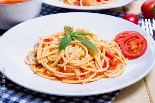 Spaghetti pasta with and tomato sauce on wood background