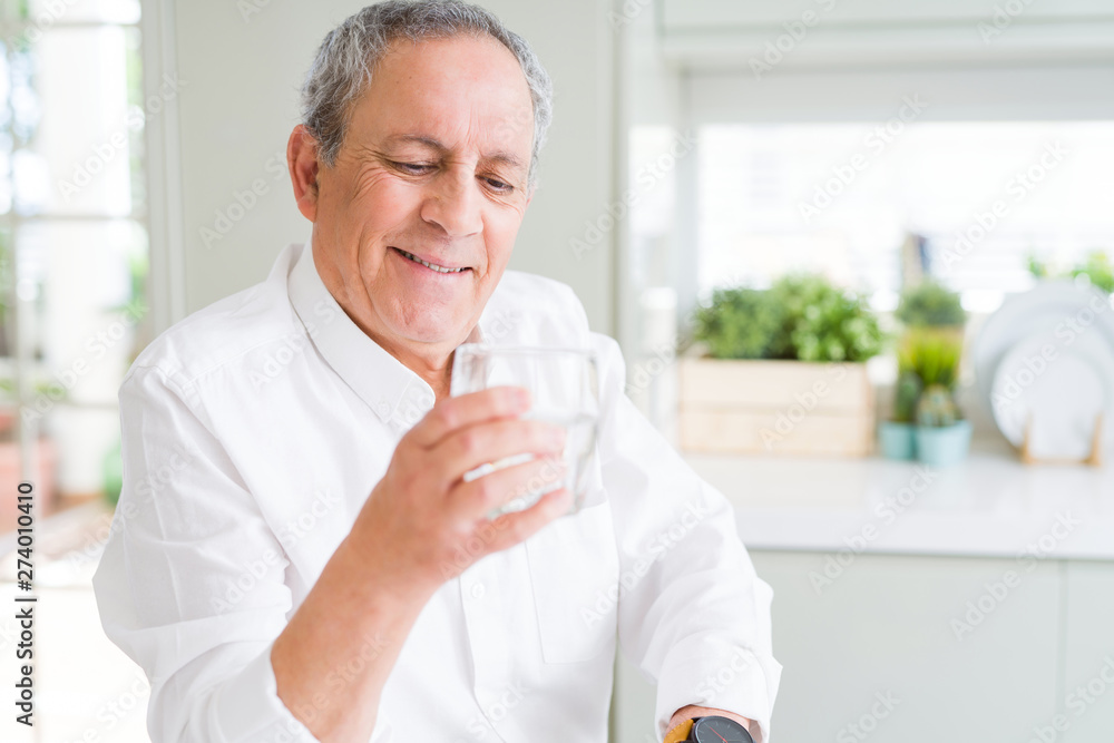 Handsome senior man holding a fresh glass of water and smiling Handsome senior man holding a fresh glass of water and smiling