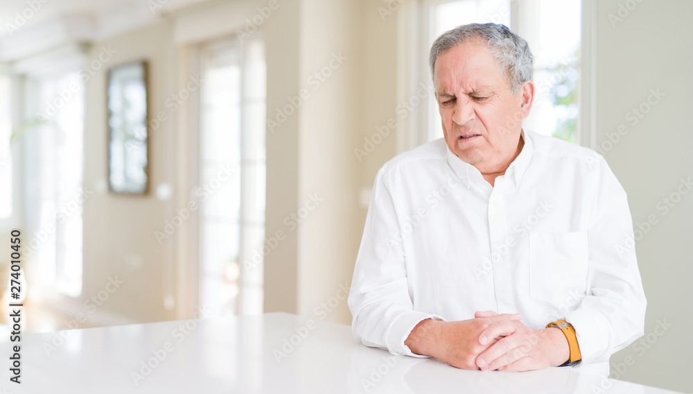 Handsome senior man at home skeptic and nervous, frowning upset because of problem. Negative person. Handsome senior man at home skeptic and nervous, frowning upset because of problem. Negative person.