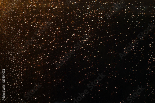 Rain drops on window in sunset lights defocused.
