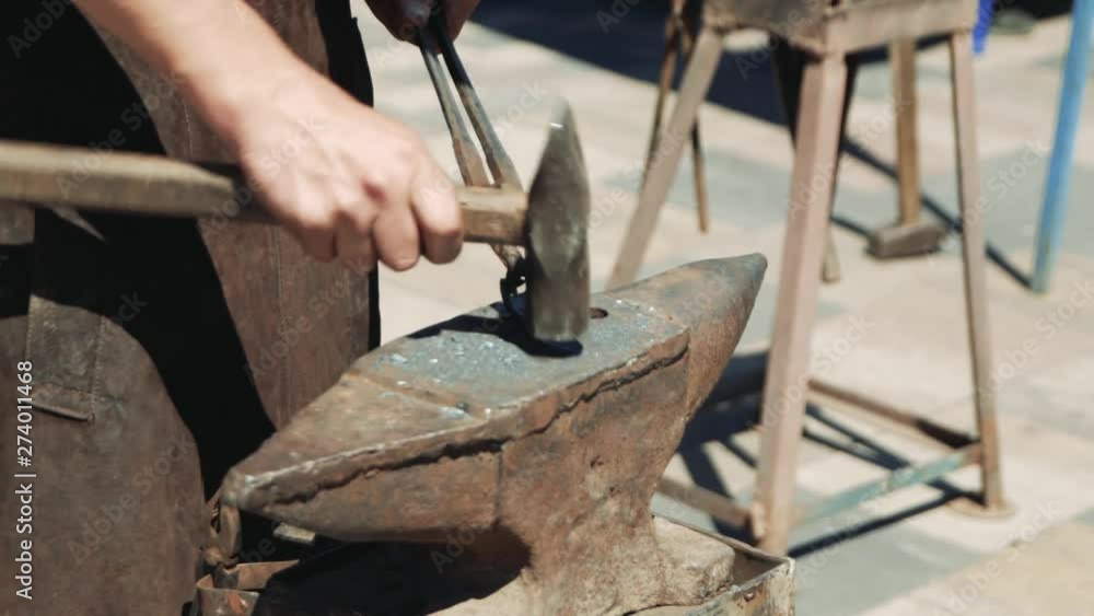 The blacksmith manually forged a heart out of metal. With a hammer and tongs, he corrects the shape of a metal heart. The blacksmith manually forged a heart out of metal. With a hammer and tongs, he corrects the shape of a metal heart.