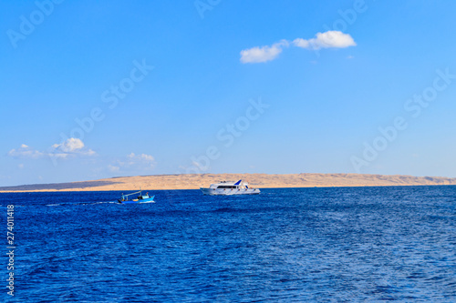 Old fishing boat and white luxury yacht sails in the Red sea  Egypt