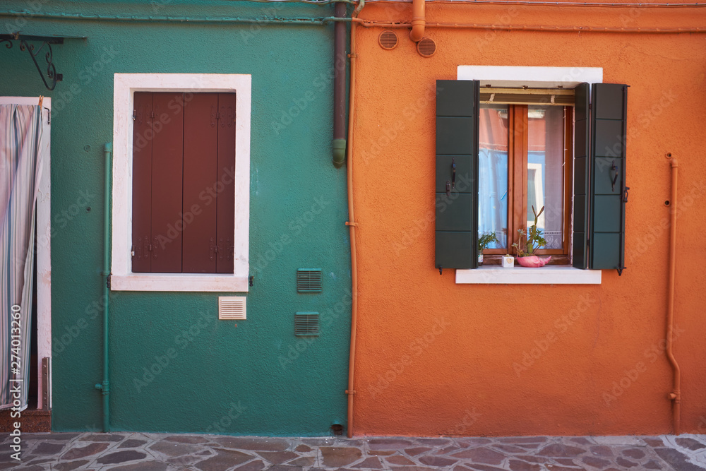 Beautiful vibrant colorful houses in Burano with narrow street near Venice in Italy.