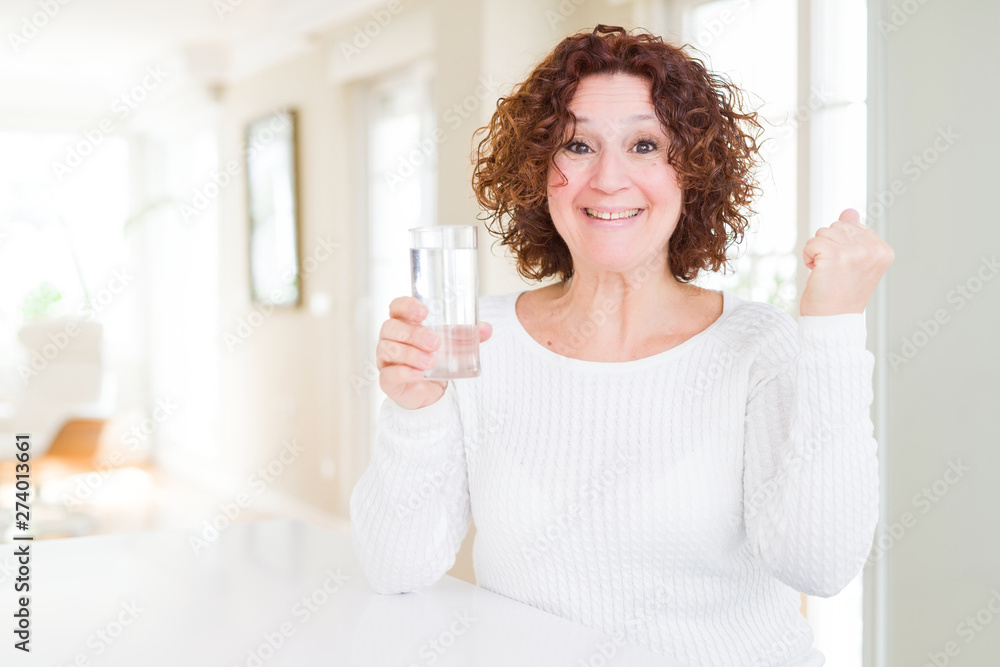 Senior woman driking a fresh glass of water screaming proud and celebrating victory and success very excited, cheering emotion Senior woman driking a fresh glass of water screaming proud and celebrating victory and success very excited, cheering emotion