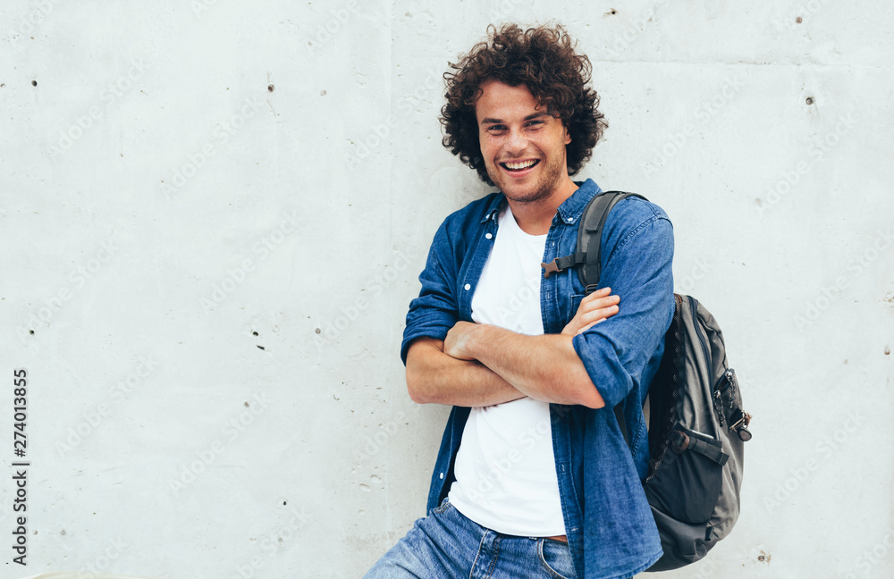 Handsome smiling young man student with backpack on the back, standing ...