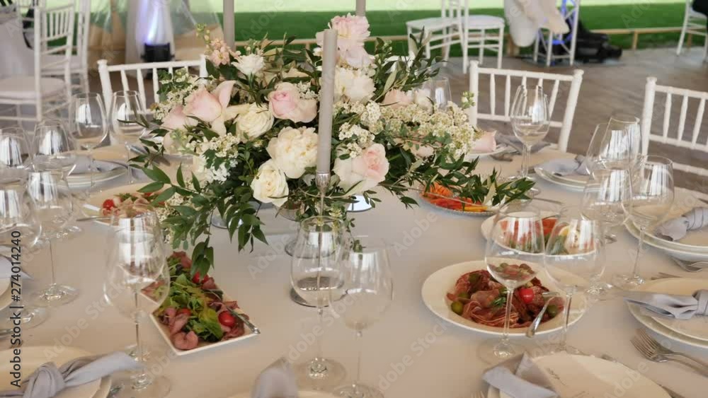 Banquet with large tables with white tablecloths assorted delicious dishes, flower arrangements candles Decor for the Wedding. Camera mothion 4k Slow motion. Banquet with large tables with white tablecloths assorted delicious dishes, flower arrangements candles Decor for the Wedding. Camera mothion 4k Slow motion.