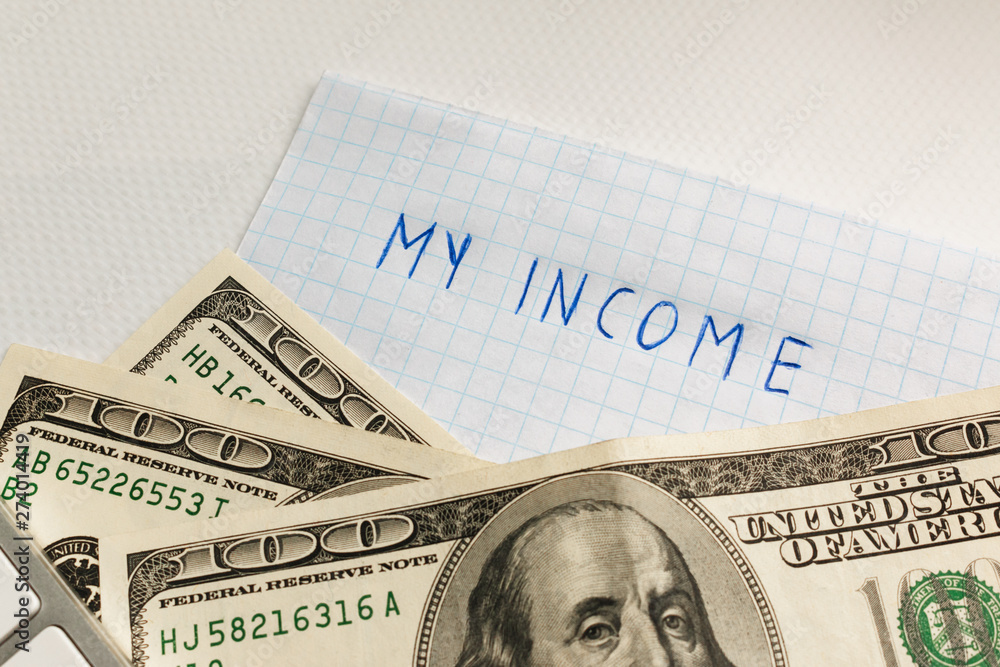 my income - the inscription on a sheet of paper with US dollars at the bottom of the frame. work, investment and savings generate income. my income - the inscription on a sheet of paper with US dollars at the bottom of the frame. work, investment and savings generate income.