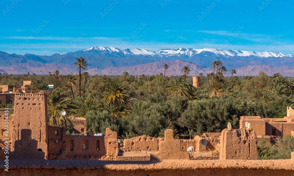 Kasbah Amridil in Skoura, Morocco, with the snowy Atlas Mountains in the distance