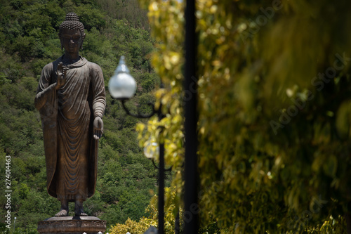big black buddha image stand in garden