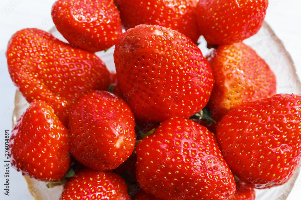 Fresh and ripe strawberries in a glass bowl, view from above. fruits that do not contain genetically modified organism. Fresh and ripe strawberries in a glass bowl, view from above. fruits that do not contain genetically modified organism.