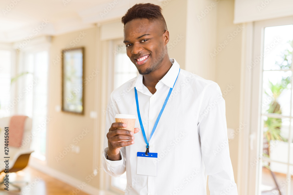 African american business man waring ID card and drinking a coffe in a take away paper cup African american business man waring ID card and drinking a coffe in a take away paper cup