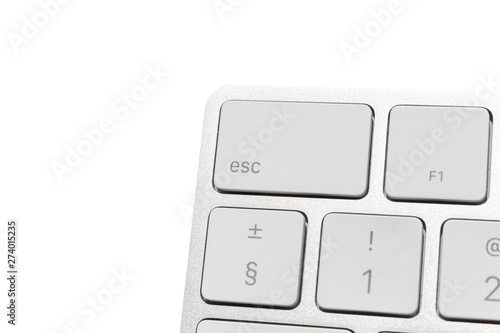 Big escape key in the corner of white wireless computer keyboard. aluminum keyboard isolated on white. Focus on escape button.
