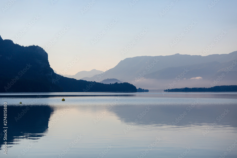 Morning fog over scenery lake Wolfgangsee in Austrian Alps