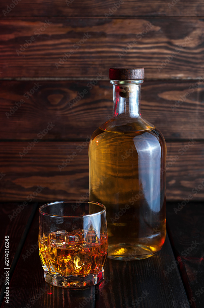 Bottle of whiskey on a wooden background.Studio photography. Bottle of whiskey on a wooden background.Studio photography.