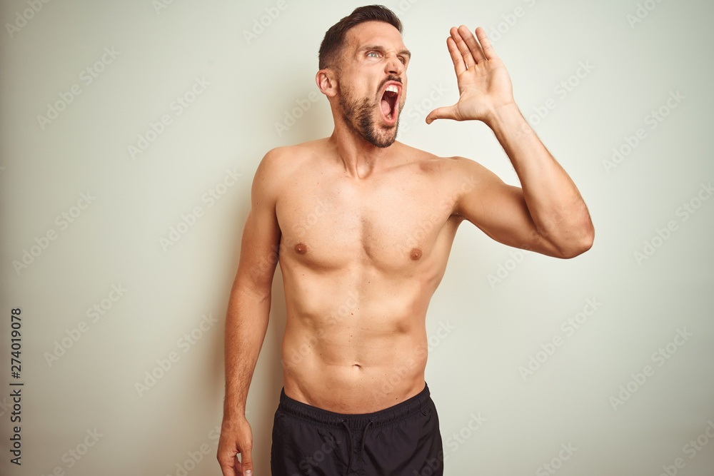 Young handsome shirtless man over isolated background shouting and screaming loud to side with hand on mouth. Communication concept. Young handsome shirtless man over isolated background shouting and screaming loud to side with hand on mouth. Communication concept.
