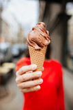 Woman in red shirt holding chocolate ice cream 