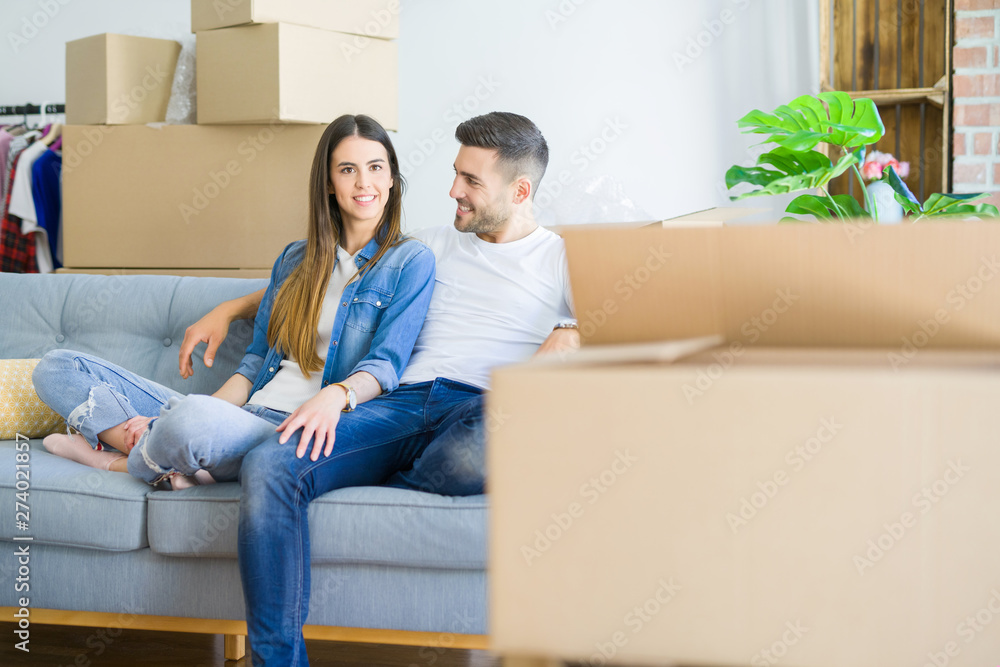 Young couple in love relaxing sitting on the sofa at new home, smiling happy for moving to new apartment Young couple in love relaxing sitting on the sofa at new home, smiling happy for moving to new apartment