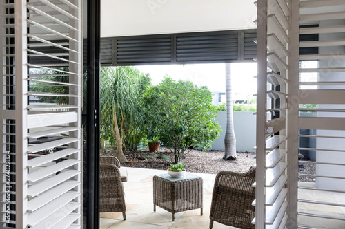 Two chairs with a mini table in between facing the lawn.