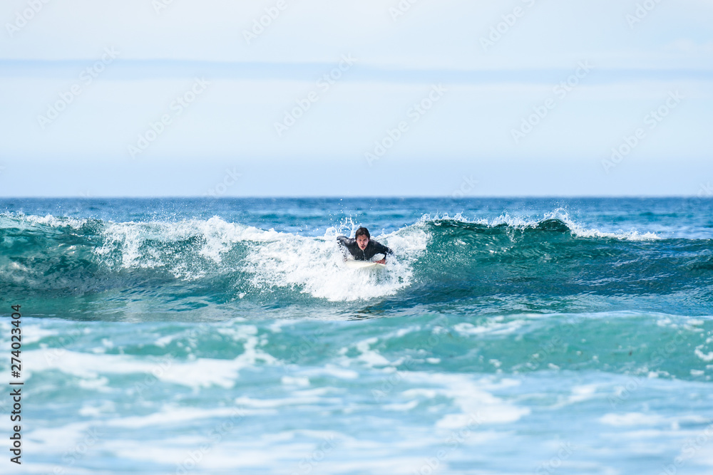 Surfer man with surfboard is paddling on the wave. Surfer man with surfboard is paddling on the wave.