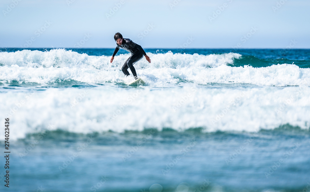 Surfer guy surfing with surfboard on waves in Atlantic ocean. Surfer guy surfing with surfboard on waves in Atlantic ocean.