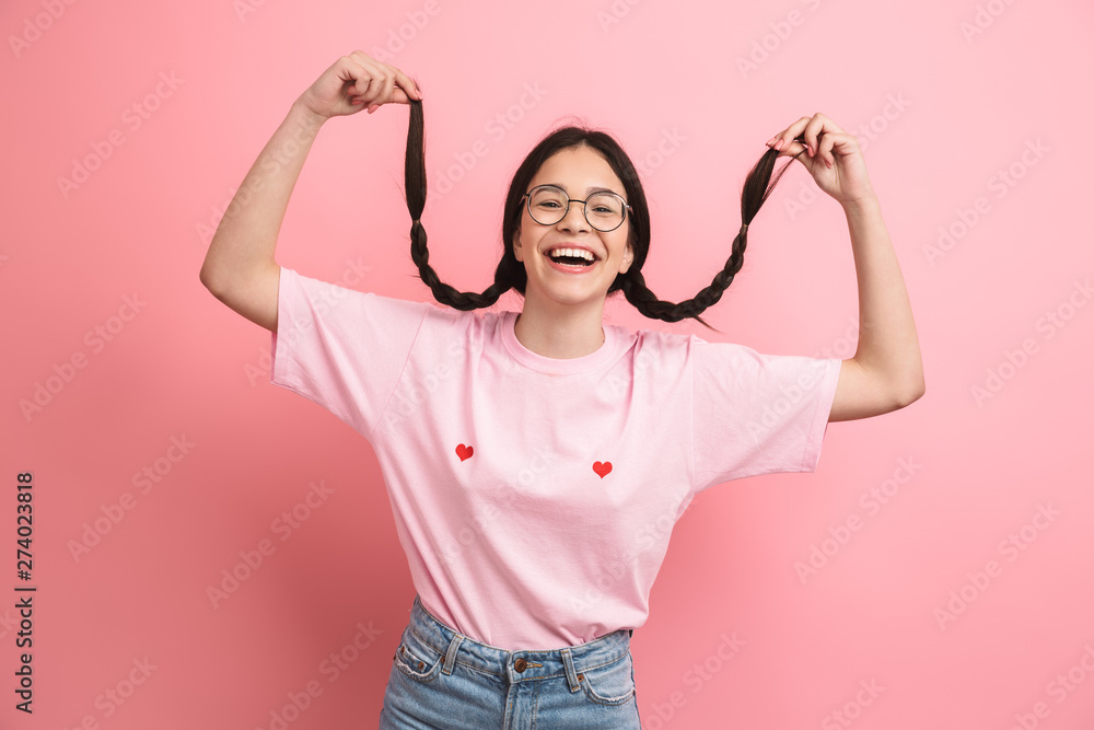 Portrait closeup of cheerful happy girl with two pigtails wearing eyeglasses having fun and smiling at camera Portrait closeup of cheerful happy girl with two pigtails wearing eyeglasses having fun and smiling at camera