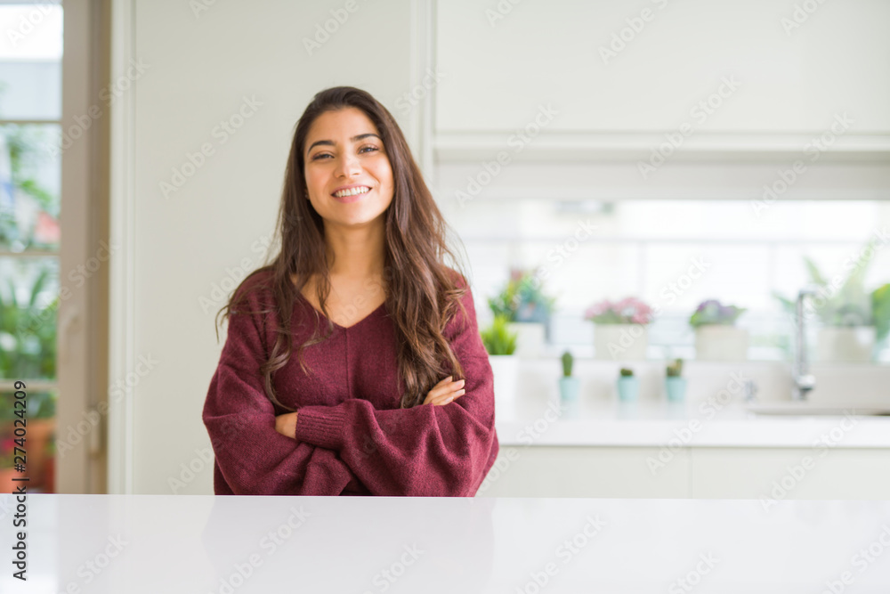 Young beautiful woman at home happy face smiling with crossed arms looking at the camera. Positive person.