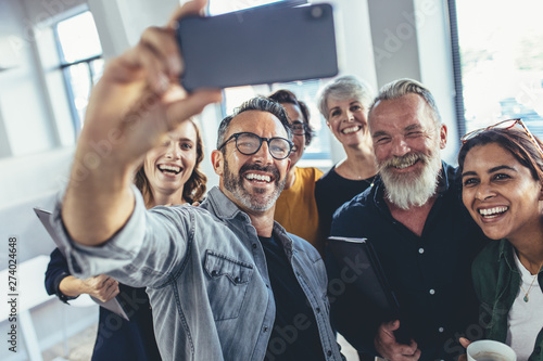 Bild auf Leinwand Multiracial group of people taking selfie at office