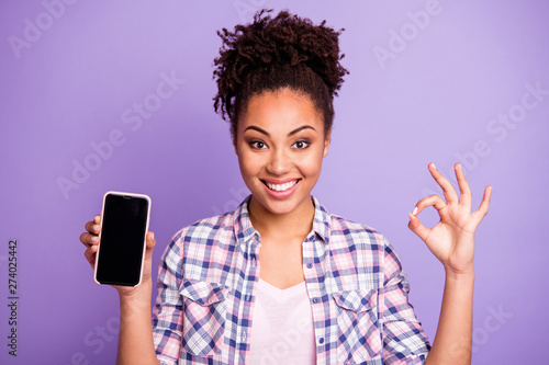 Close up photo positive cheerful lady student beautiful top-knot hold hand modern technology advise decision excellent choice recommend advertise trendy stylish plaid shirts isolated purple background