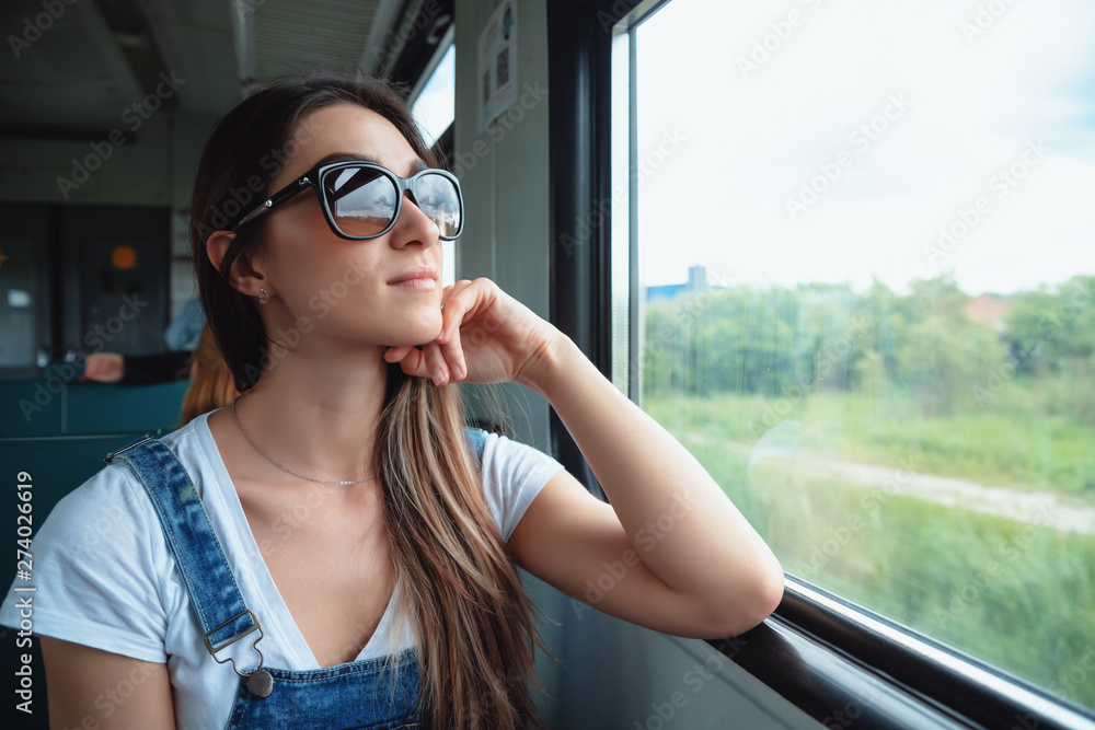 © Георгий Окунев - A young girl in sunglasses on the train looking out the window. Good mood in the journey © Георгий Окунев - A young girl in sunglasses on the train looking out the window. Good mood in the journey