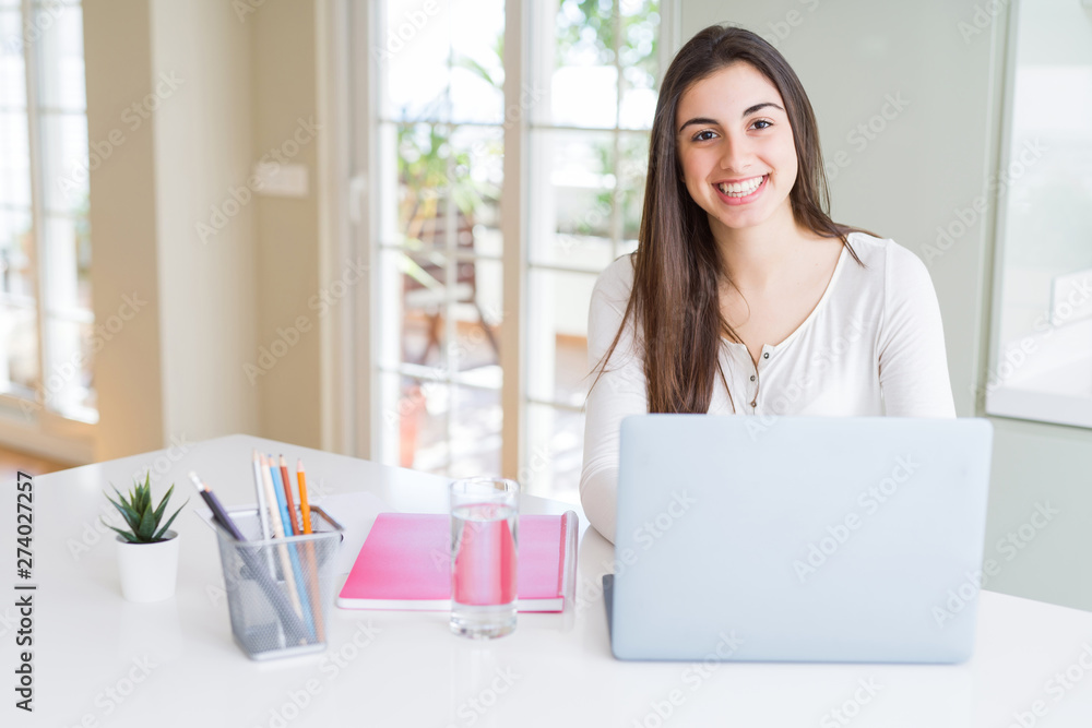 Young beautiful woman smiling happy and working using computer laptop Young beautiful woman smiling happy and working using computer laptop