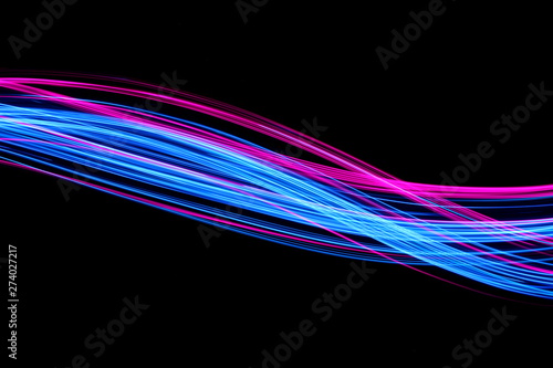 Long exposure, light painting photography.  Vibrant electric blue and neon pink streaks of colour against a black background © LizFoster