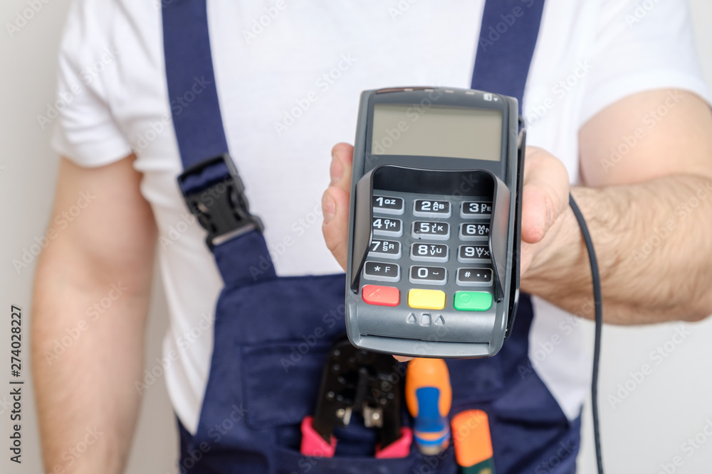Man with tools holding bank payment terminal Man with tools holding bank payment terminal