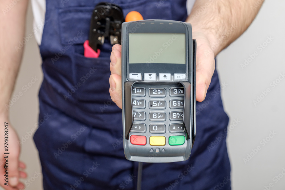 Man with tools holding bank payment terminal Man with tools holding bank payment terminal