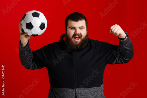 Happy young man holding a soccer ball