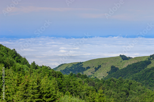 Beautiful scene of green mountain hills and fog and blue sky