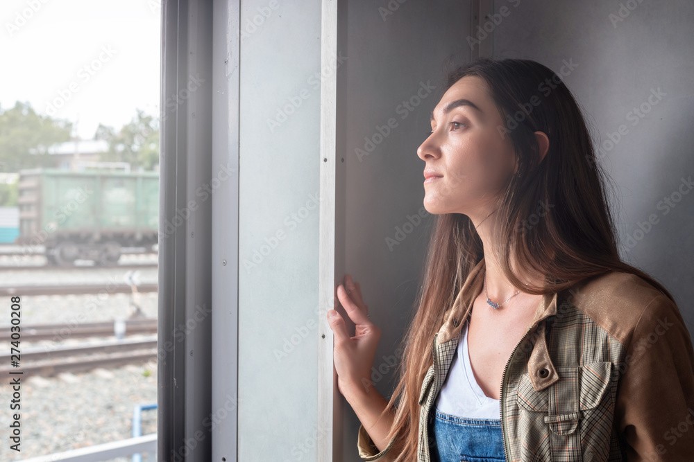 a young girl looks out of the train door. the girl goes on vacation a young girl looks out of the train door. the girl goes on vacation