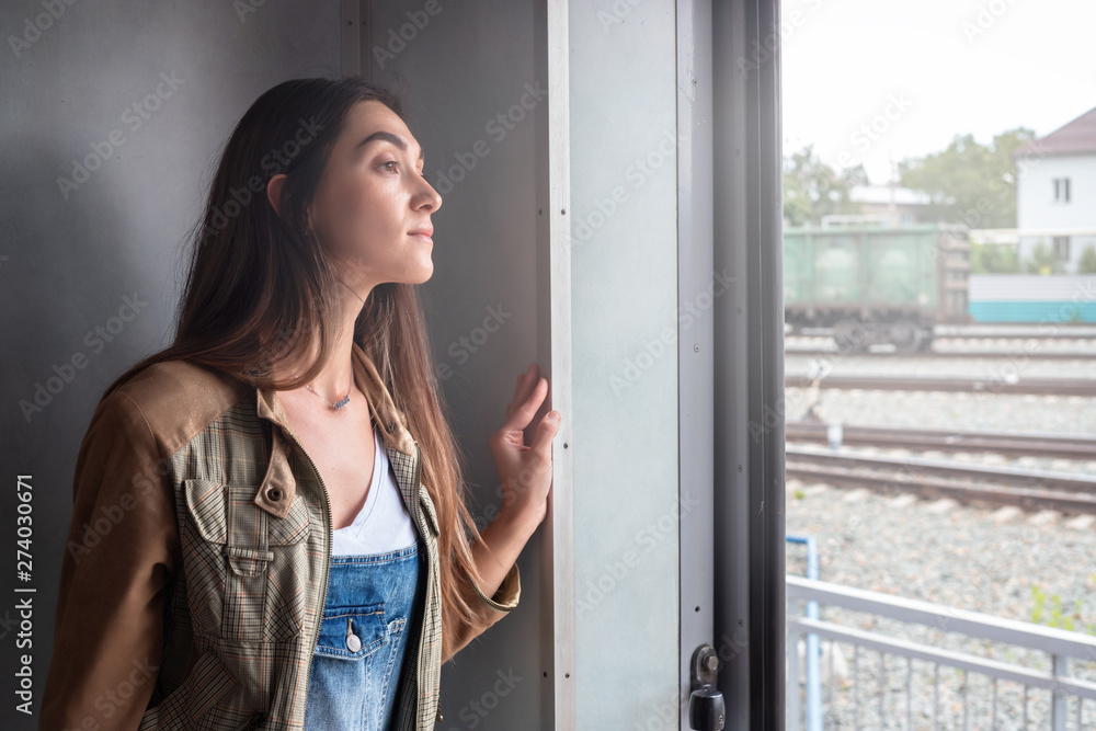 a young girl looks out of the train door. the girl goes on vacation a young girl looks out of the train door. the girl goes on vacation